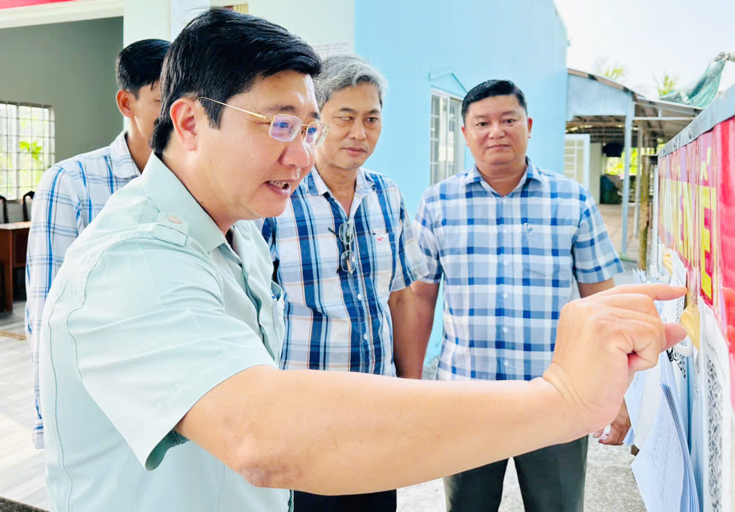 Các thành viên Uỷ ban Bầu cử xã kiểm tra danh sách niêm yết cử tri ấp Bình Minh